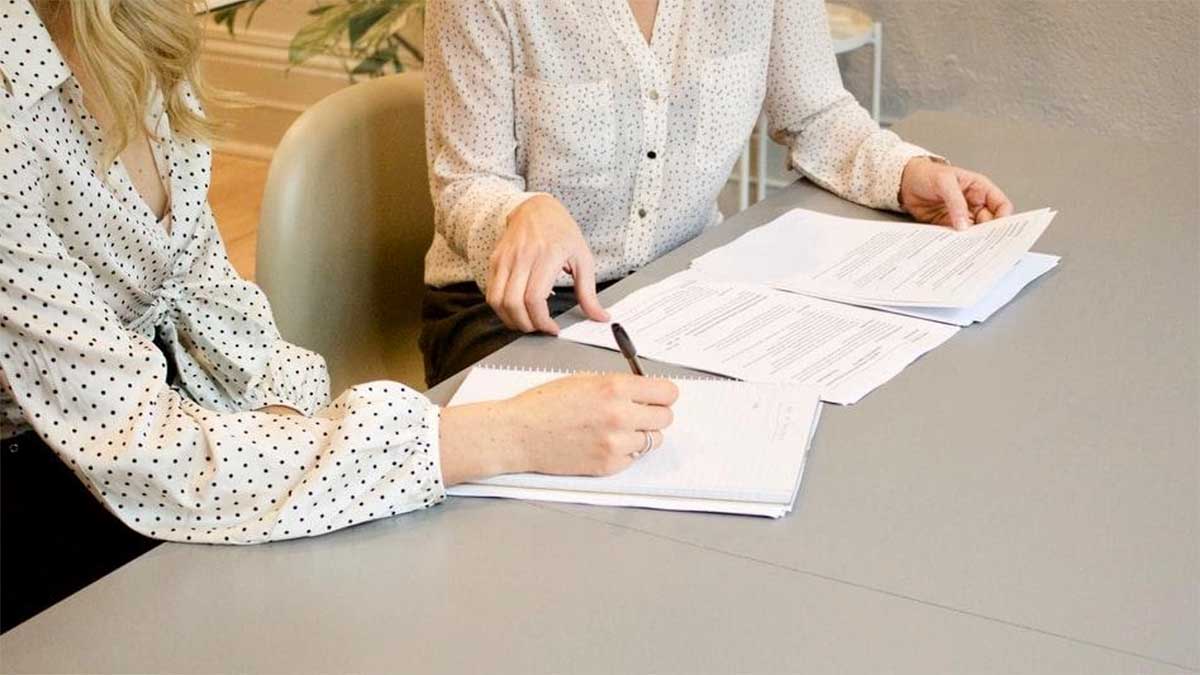 close up of two professionals negotiating a real estate contract on a gray table